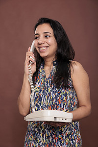 微笑的印地安妇女接听座机电话