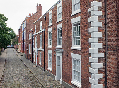 英格兰切斯特一条优雅的大砖砌 19 世纪房屋街道，铺有鹅卵石路面和道路