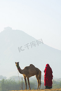 站在骆驼旁边的女人