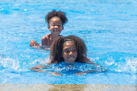 一群黑人儿童在炎热的夏季在户外快乐地玩水池公园
