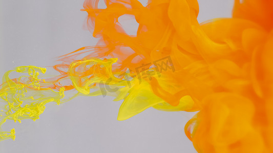 油漆滴摄影照片_溶解在水中的红色和黄色油漆滴。
