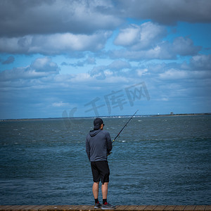 秋天木板背景摄影照片_年轻人去钓鱼