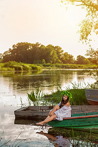 头戴花环的年轻女子，日落时分在河上的船上放松。