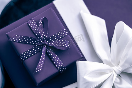 礼物箱摄影照片_节日礼物和包装好的豪华礼物、紫色礼盒作为生日、圣诞节、新年、情人节、节礼日、婚礼和假日购物或美容盒交付的惊喜礼物