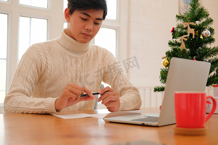 男人想用圣诞装饰写圣诞贺卡节日祝福