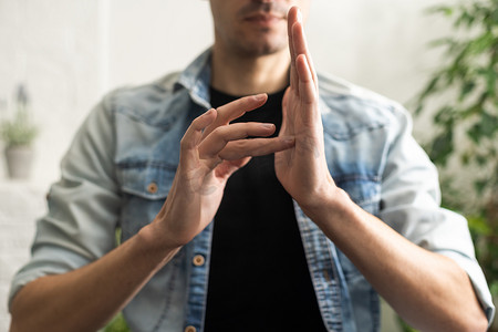学手语摄影照片_在白色背景上用手语显示手势的人