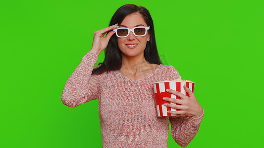 电影视频片摄影照片_戴着 3D 眼镜的兴奋女人吃爆米花，看有趣的电视连续剧、体育游戏电影