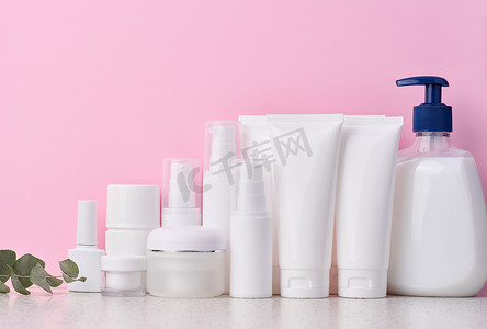 粉红色背景中用于化妆品的白色塑料管、罐子和容器、产品广告和品牌