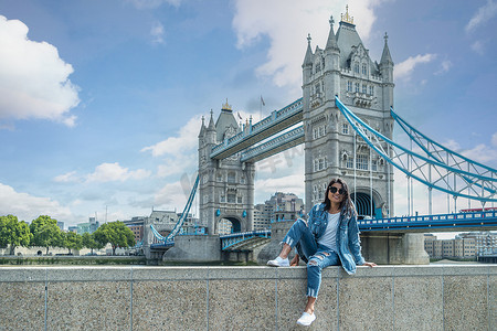 城市之旅摄影照片_伦敦泰晤士河畔伦敦塔桥著名景点的亚洲女性城市之旅