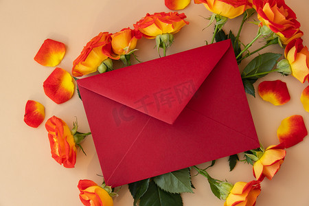 美丽的红玫瑰花在中性米色背景的邮政红包中，复制文本空间，春天，节日贺卡。