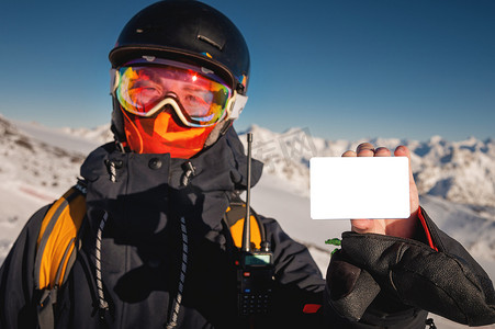 滑雪者拿着一张空的电梯通行证，背景是一座山。