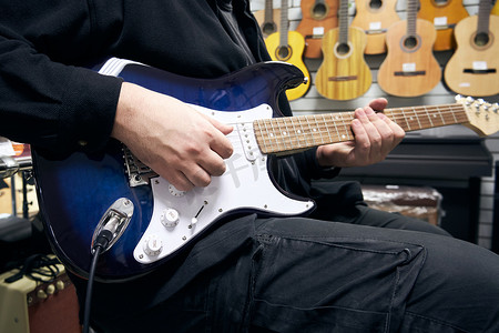 器材音乐摄影照片_吉他手在吉他店弹吉他
