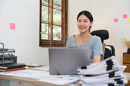 肖像会计亚洲女性从事财务工作，使用笔记本电脑进行文书工作。