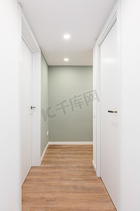 明亮的走廊，带有通往带门的房间的入口并向右转。