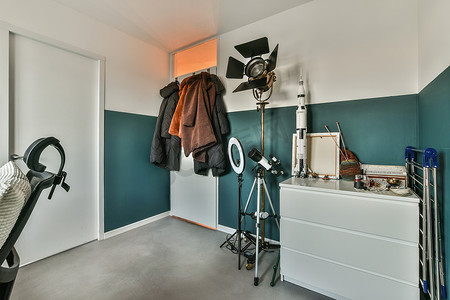 衣柜窗户摄影照片_一个有衣柜、望远镜和衣服的房间