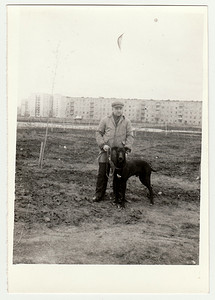 冬天遛狗摄影照片_复古照片显示男人遛狗。