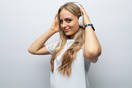 戴着白色耳机的快乐年轻女性在白色背景下收听播客