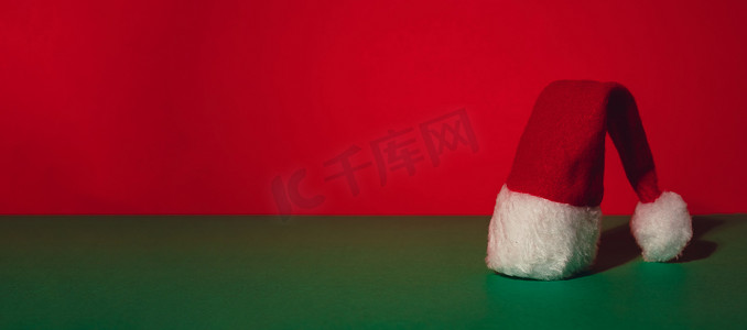 等距绿色红色背景上的圣诞老人帽子。