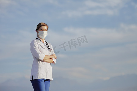 女医生、护士戴着防护面罩，抵御蓝天白云