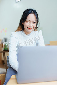 开始使用电脑笔记本电脑微笑的独立亚洲女性的小企业企业家在线营销包装盒项目和 SME 交付概念的欢快成功