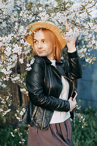 戴草帽的女孩摄影照片_樱花中戴草帽的女人画像。