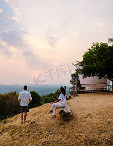 一对男女在泰国彭世洛的山间露营地看日落