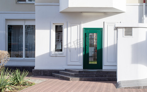 门样机摄影照片_白色墙壁和绿色门的建筑外观，模型设计