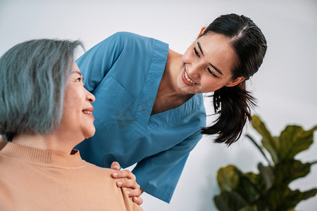 一位护理人员将她的手放在一位心满意足的老年患者的肩膀上。