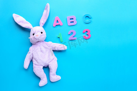 白色 ba 上有英文字母拼图和数字的兔子玩具