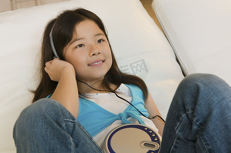 听音乐的儿童摄影照片_在 CD 播放器上听音乐的女孩