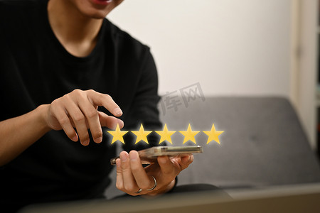 男人用手按在智能手机屏幕上，获得五星级黄金评级，给予积极反馈。