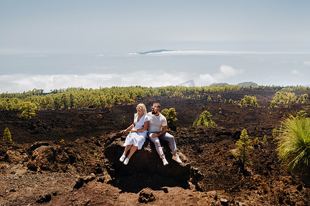 正泰电工logo摄影照片_一对热恋中的情侣正坐在泰德火山的斜坡上。