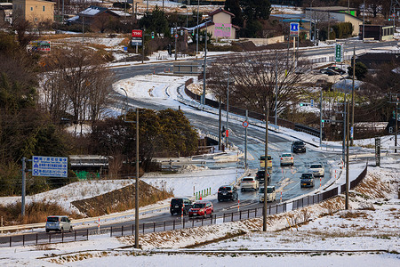 日本Sekigahara - 2022年12月25日：雪地小镇弯曲道路上的轻型交通