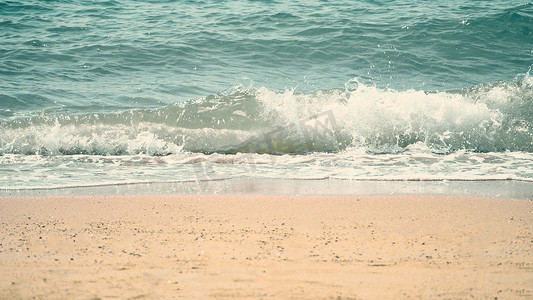 浅蓝色水花摄影照片_清澈的浅蓝色海水飞溅到海滩