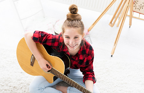 有乐器的微笑的女孩吉他弹奏者