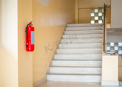 灭火器灭火摄影照片_一个灭火器挂在楼梯上。