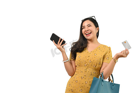 开朗时尚女性手持手机和信用卡的肖像，在白色背景下显得格格不入