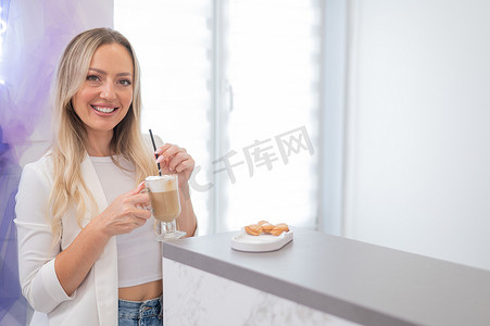 客户接待摄影照片_一家美容院的女客户在前台喝咖啡。
