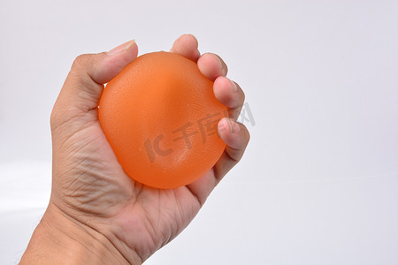 疗法摄影照片_男人的手在挤压压力球，手部力量疗法挤压握力球