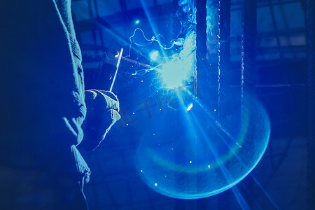 工人正在工厂或工业企业的金属结构上进行焊接工作