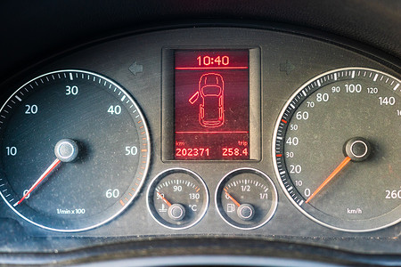 尘土飞扬的汽车仪表板面板，带有速度计和隔离的开门指示器。