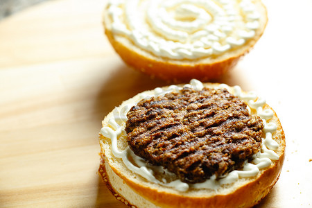 汉堡小吃摄影照片_牛肉饼放在面包上做汉堡特写