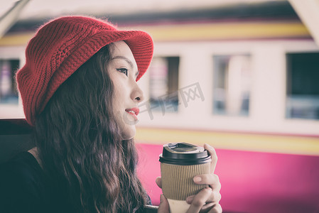 亚洲女游客在旅行时喝了一杯咖啡
