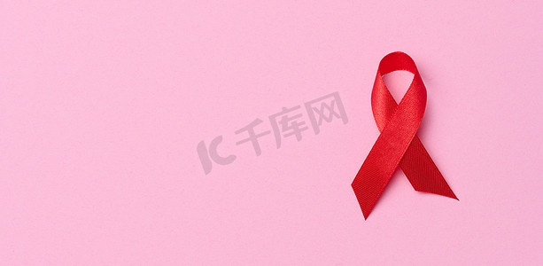 粉红色背景上呈蝴蝶结形式的丝绸红丝带，是抗击艾滋病的象征，也是团结和支持的象征