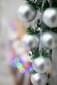 在圣诞节期间装饰的云杉树枝上的银饰的特写视图。