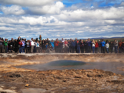 冰岛，STROKKUR，2016 年 7 月 26 日：就在 Strokkur 间歇泉喷发黄金圈之前的泡沫，一大群穿着五颜六色的游客拍照并等待喷泉间歇泉喷发。 