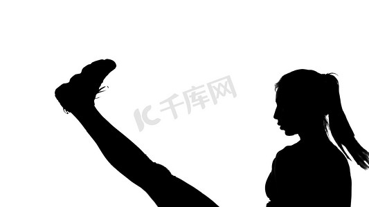 在白色背景上，一个影子，一个做拳击动作的女性人物的黑色轮廓，与影子的战斗，踢腿，跆拳道，模仿打击，战斗技巧，