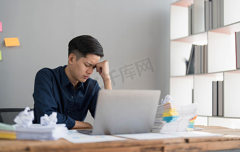 地签摄影照片_疯疯癫癫的男员工坐在办公室工作场所，周围到处都是便签，愤怒地大喊大叫，对截止日期和办公室压力大的工作感到愤怒