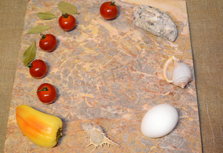 蔬菜免费摄影照片_大理石表面上的蔬菜、鸡蛋和贝壳，有自由空间：樱桃番茄、甜椒、大蒜和月桂叶