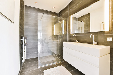 浴室玻璃摄影照片_带白色水槽和玻璃淋浴间的浴室